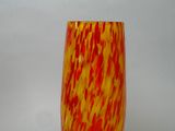 a yellow and red vase sitting on a table