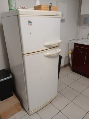 un réfrigérateur blanc dans le coin d'une cuisine