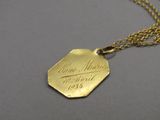 a close up of a gold plated necklace with a gold chain