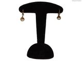a close up of a pair of earrings on a stand