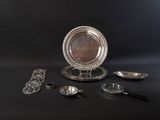 a silver plate with a mirror on it next to other silver objects