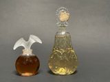 two bottles of perfume sitting next to each other on a table