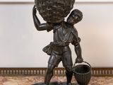 statue en bronze représentant un garçon portant un panier sur la tête