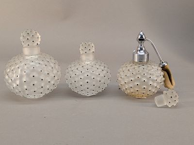 trois flacons de parfum posés les uns à côté des autres sur une table