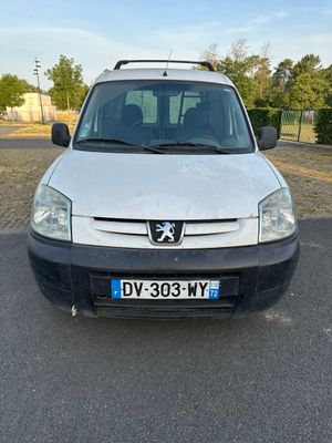 la petite camionnette blanche est garée dans le parking