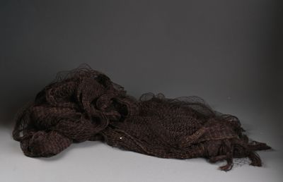 un petit ours en peluche marron posé sur une table blanche