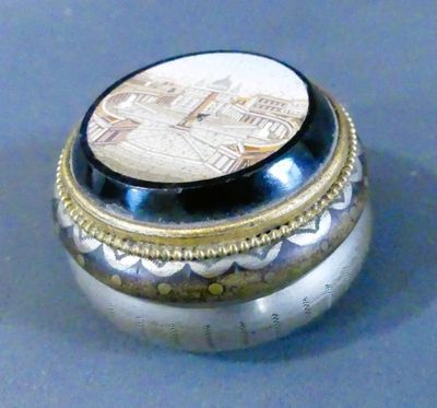 une boîte en argent ornée d'une image, posée sur une table