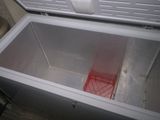 a white chest freezer with a red basket inside of it