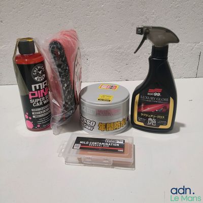une bouteille de produit nettoyant et une bouteille de cire à côté d'un lot de produits d'entretien