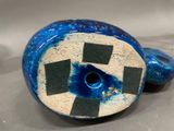 a blue vase with a black and white checkerboard design on it