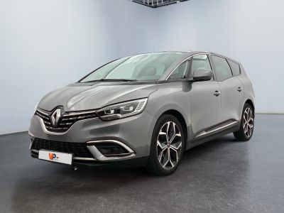 La voiture grise est garée dans une grande pièce équipée d'un ventilateur de plafond.