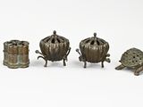three bronze figurines of turtles sitting next to each other on a white surface