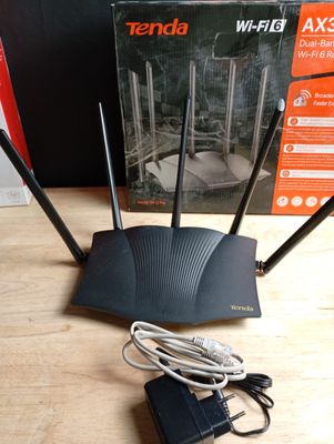 On voit l'image d'un routeur sans fil posé sur une table à côté d'un carton.
