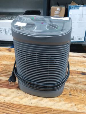 an air purifier sitting on top of a wooden table next to a box of boxes