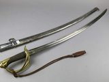 two swords are laying next to each other on a white surface