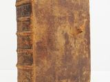 an old book sitting on top of a white surface