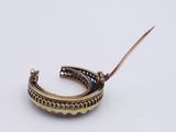 a close up of a gold bracelet on a white surface