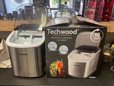 une boîte contenant une machine Techwood et un mixeur posés sur un plan de travail