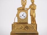une horloge en or surmontée d'une statue
