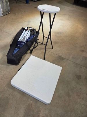 a white table and a black bag on the floor