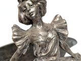 a statue of a woman sitting on top of a bowl