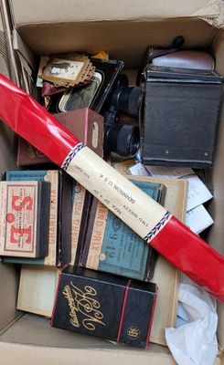 une boîte en carton remplie de livres et une batte de baseball rouge