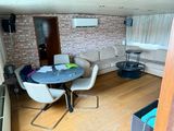 a room with a couch, table, chairs, and a television