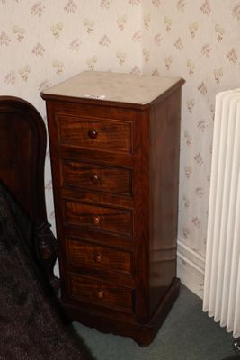 une petite commode posée à côté d'un lit dans une chambre
