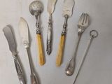 a lot of silverware on a table with spoons and forks