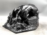 a statue of a dog laying down on a rock
