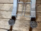 two pieces of metal sitting on a wooden floor