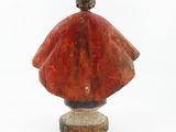 statue of a woman in a red cloak with a bird on her head