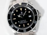 a rolex watch that is sitting on a white surface