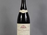 une bouteille de vin posée sur une table à côté d'un verre