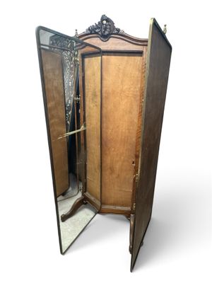 une grande armoire en bois surmontée d'un miroir