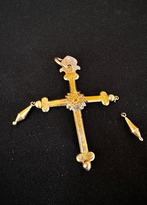 un gros plan d'une croix sur une surface noire