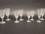 six clear wine glasses lined up in a row on a table