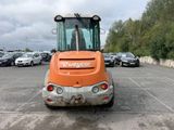 an orange construction vehicle that is parked in a parking lot