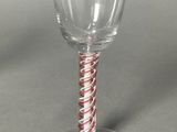 a wine glass with a red and white striped stem