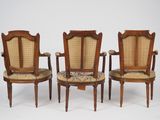three chairs with upholstered arms and a cane back