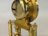a gold clock that is sitting on top of a table