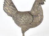 un poulet argenté posé sur une surface blanche