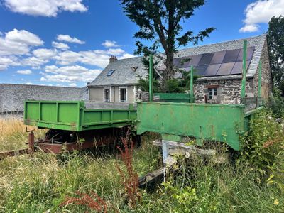 un camion-benne vert garé devant une maison