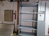 a metal shelf in a room with a fire extinguisher