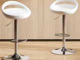 two white bar stools sitting next to each other on a wooden floor