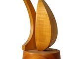 a wooden sculpture of a sailboat on a stand