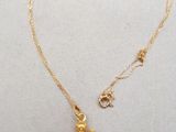 un collier plaqué or orné d'un petit ours en or