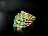 a close up of a gold ring with emeralds and diamonds