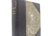 an old black book with gold trim and a gold cover