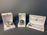 three silverplated spoons and a silver plate in a box